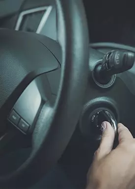 hand turning the ignition of a car
